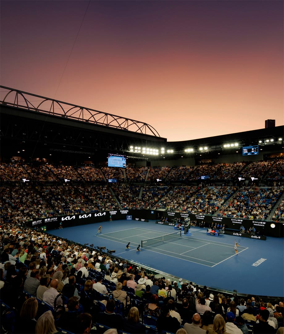 La cancha principal del Australian Open llena de espectadores al atardecer.