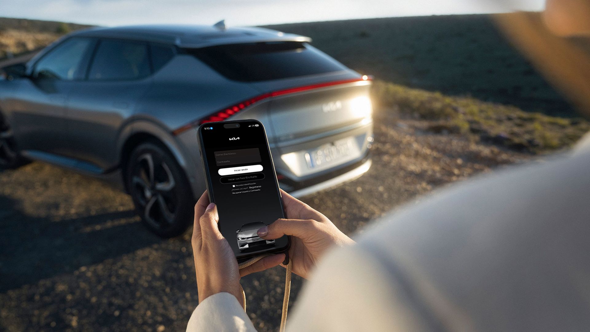 Woman looking at a mobile phone with Kia Connect app on