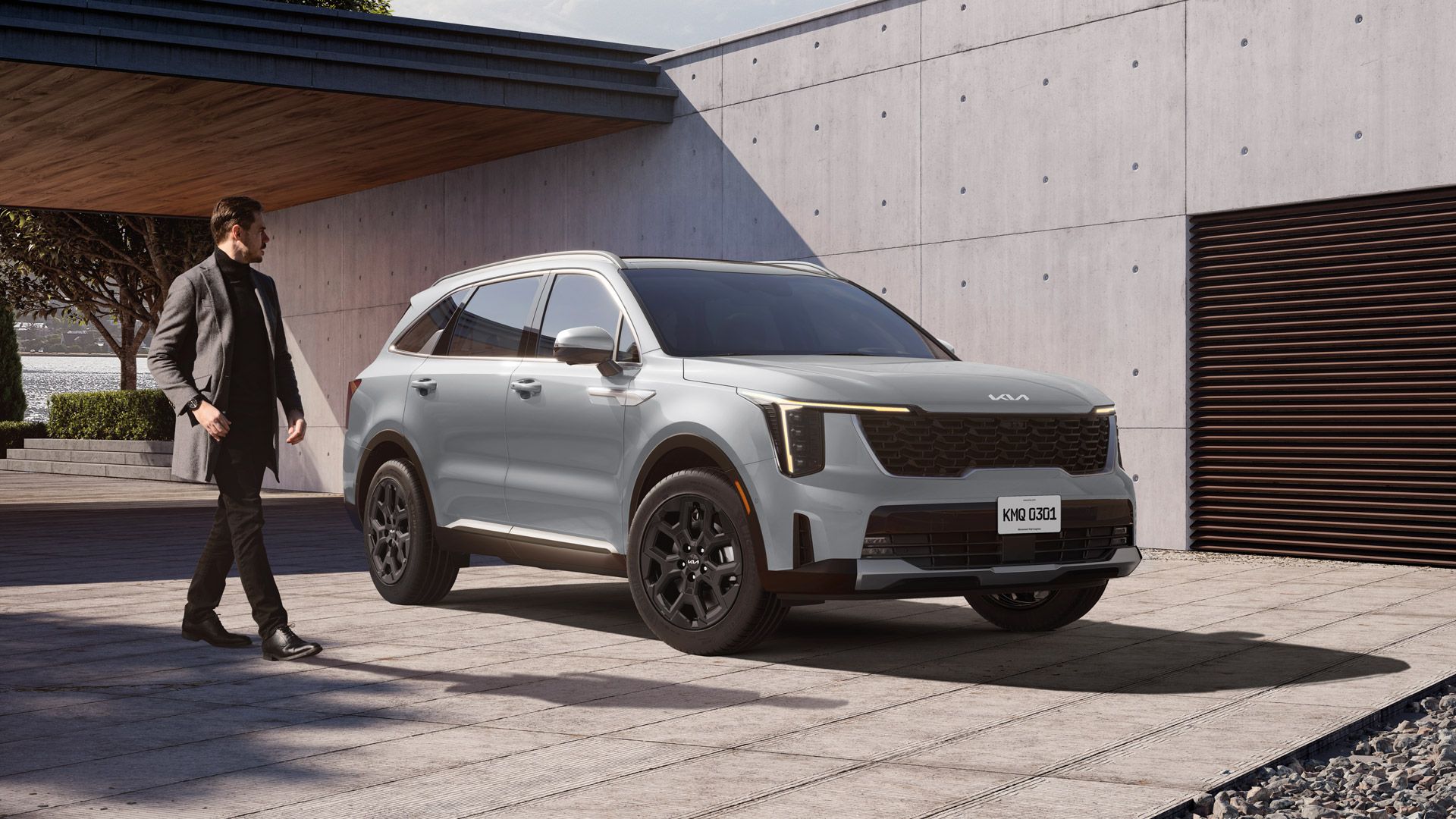 Front side view of Kia EV9 parked in front of a high wall